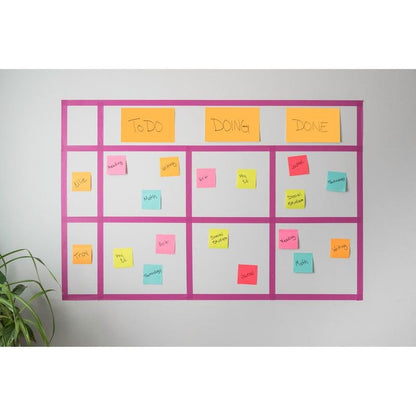 Een aan de muur gemonteerd Kanban-bord toont kleurrijke 3M Deutschland GmbH Post-it® Super Sticky Notes (76x127mm, 90 vel, 100% PEFC), die met taken en namen in de kolommen "Te doen", "In uitvoering" en "Voltooid" zijn gelabeld. In de linkerbenedenhoek verschijnt een groene plant.
