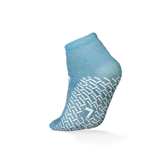 Abgebildet ist eine einzelne ECO-PLUS Anti-Rutsch Einwegsocke der AMPri Handelsgesellschaft mbH in hellblau mit weißem Antirutsch-Muster und der Zahl "7" auf der Sohle, ideal für den medizinischen Einsatz, vor einem schlichten weißen Hintergrund.