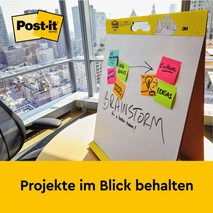 Im Büro mit Stadtblick steht ein 3M Post-it® Super Sticky selbsthaftendes Meeting Chart/Flipchart mit Aufsteller (58,4x50,8 cm, 20 Blatt/Block) - perfekt für Notizen wie "We Propose", "Save Spaces" und mehr. Projekte im Blick behalten.