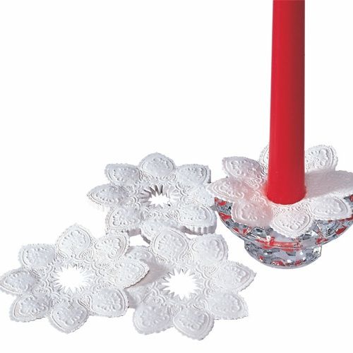 Drie ronde, witte PAPSTAR kaarsmanchetten (Ø 10 cm, folie) zijn te zien: een gewikkeld om een rode kaars in een glazen houder, twee liggend - en tonen hun elegante en decoratieve ontwerp van de PAPSTAR GmbH.