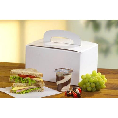 Een PAPSTAR 20 lunchbox van milieuvriendelijk karton (12,5x15,5x22,5 cm) met draaggreep van PAPSTAR GmbH staat op een houten tafel naast een sandwich, chocolade-vanillepudding, twee pralines en groene druiven.
