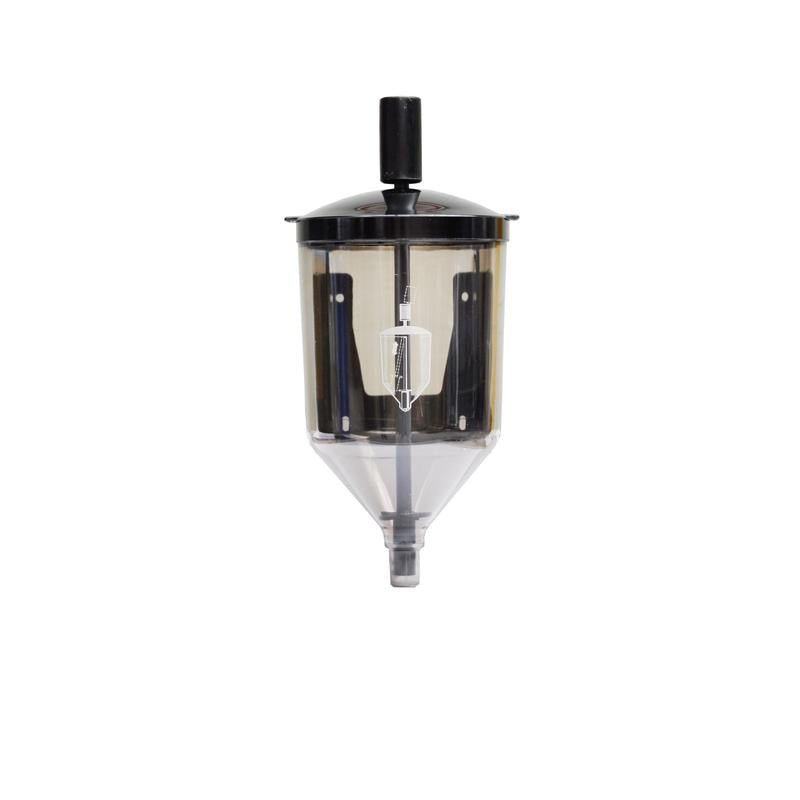 De Reinol pastadispenser van Diversey Deutschland GmbH & Co. OHG is een transparante kunststofdispenser met zwarte deksel en handgreep, witte centrale mechaniek en conische uitloop, ideaal voor Reinol S handwaspasta's. Verpakking: 1 stuk. Afgebeeld op witte achtergrond.