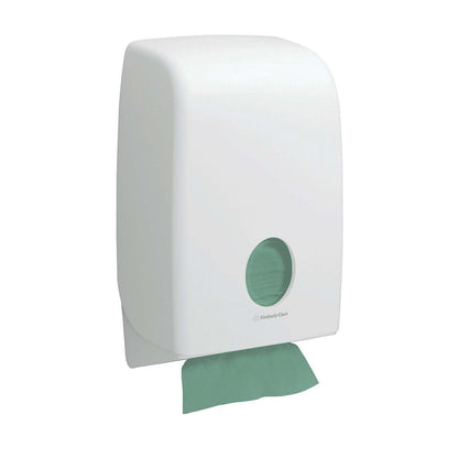 Een witte wanddispenser met een cirkelvormig venster toont groene Kimberly-Clark GmbH Hostess™ NATURA™ zigzagvouw handdoeken (23 x 25 cm); een milieuvriendelijke handdoek wordt gedeeltelijk aan de onderkant gedistribueerd.