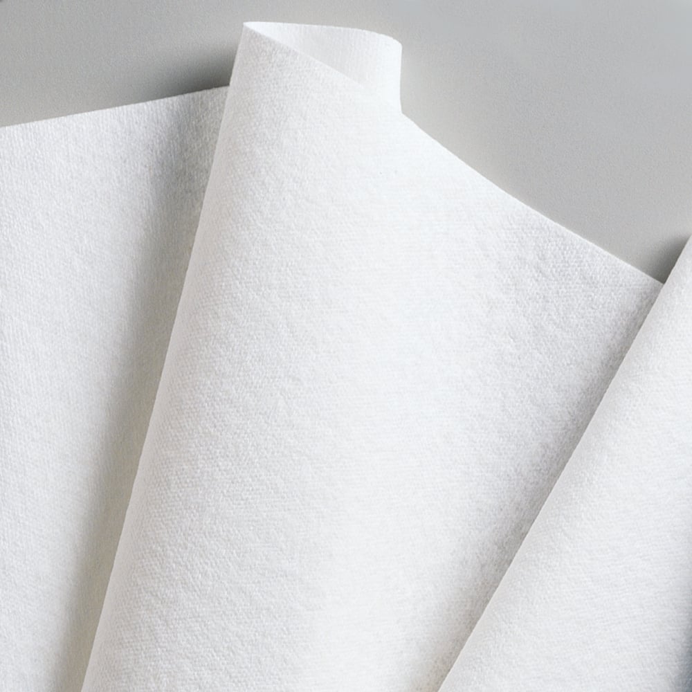 Close-up van overlappende Kimberly-Clark GmbH WypAll® L40 PowerClean kwartgevouwen papieren handdoeken (wit, 18 verpakkingen x 56 vellen), schuin geplaatst voor een neutrale achtergrond.