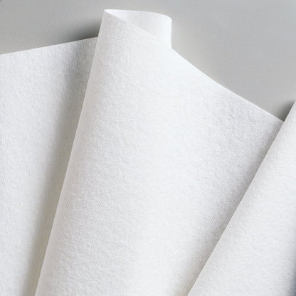 Close-up van overlappende Kimberly-Clark GmbH WypAll® L40 PowerClean kwartgevouwen papieren handdoeken (wit, 18 verpakkingen x 56 vellen), schuin geplaatst voor een neutrale achtergrond.