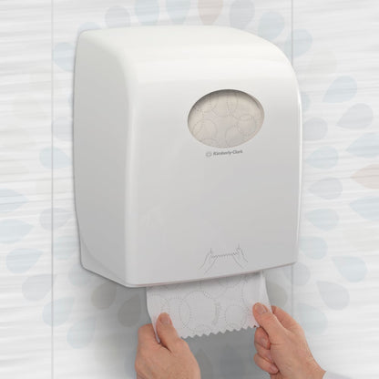 Een persoon trekt een Kleenex® ULTRA™ handdoeken-rol (wit, 150m) van Kimberly-Clark GmbH uit een muurlader in een toilet en zorgt zo voor hygiënisch handen drogen. Verpakking: 6 rollen/doos.