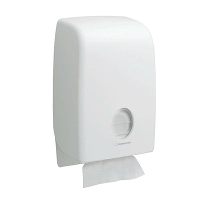 Een witte, aan de muur gemonteerde Kimberly-Clark Scott® Essential™ handdoekdispenser met rond venster toont binnenin vouwhanddoeken (Wit, Klein, 15 clips x 340 vellen) en een handdoek die gedeeltelijk wordt uitgegeven voor hygiënisch handen drogen.