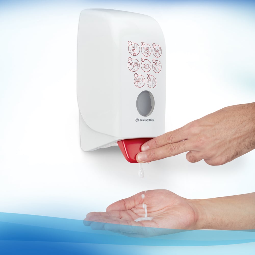 De gebruiker drukt op de hendel van het Scott® CONTROL handdesinfectieschuim op alcoholbasis (1L cassette) van Kimberly-Clark GmbH en brengt het schuim op zijn hand aan. Op de voorkant van de transparante wandunit zijn symbolen voor handhygiëne afgebeeld.