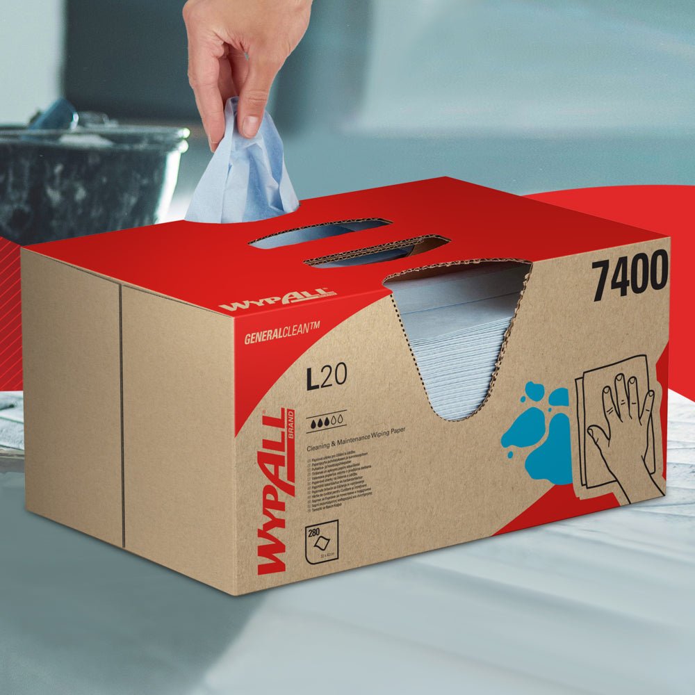 Een hand trekt een WypAll® L20 General Clean doekje uit een blauwe BRAG™ Box van Kimberly-Clark GmbH, die 280 vellen bevat, en legt het op een glad oppervlak.