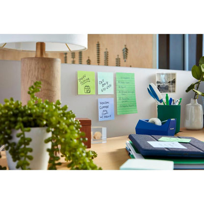 Op een opgeruimd bureau staan een lamp, een kamerplant, een plakbandhouder, pennen, ordners en 3M Deutschland GmbH Post-it® Super Sticky Z-Notes (Boost Collection). De notities op de scheidingswand tonen herinneringen, een telefoonnummer en een koffievergadering.