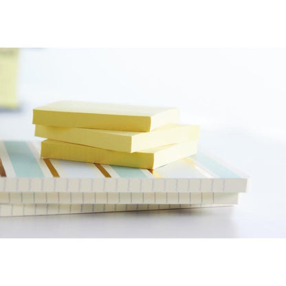Drie stapels Post-it® Recycling Z-Notes (76x76 mm, 100 vel/Blok, 100% PEFC) van 3M Deutschland GmbH rusten op twee gestreepte notitieboeken in helder licht met een zacht vervaagde achtergrond.