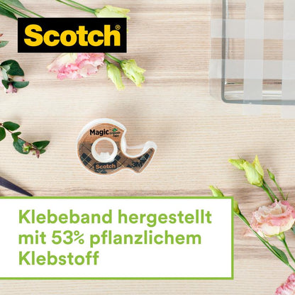 Een Scotch™ roestvrijstalen plakbandhouder in zilver met twee rollen Scotch® Magic™ plakband (gemaakt van 66% plantaardige lijm, 19 mm x 13,9 m) van 3M Deutschland GmbH staat op licht hout naast roze en gele bloemen.