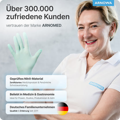 Een glimlachende vrouw in een witte polo met "ARNOWA"-naambordje houdt ARNOMED NITRIL PEPPERMINT GREEN wegwerphandschoenen van nitril mintgroen van ARNOWA GmbH omhoog. Gecertificeerd nitril, latexvrij - ideaal voor medisch en horeca. Duitse vlag in zicht.