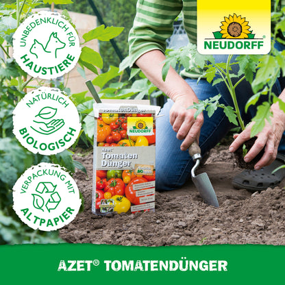 Eine Person benutzt eine Gartenkelle in der Nähe von Tomatenpflanzen und hat eine Kiste Neudorff Shop Azet TomatenDünger dabei. Umweltfreundliche und haustierfreundliche Icons heben diesen organischen Dünger für "eine reiche Ernte" hervor.