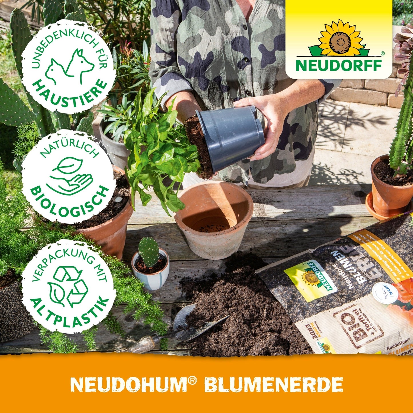 Een persoon bij het verpotten van een plant aan een tafel met aarde, gepotte tuinplanten, tuingereedschap, zakken potgrond en een NeudoHum BlumenErde-zak van Neudorff Shop. Naast het Neudorff-logo verschijnen de symbolen voor milieuvriendelijkheid en huisdiervriendelijkheid.