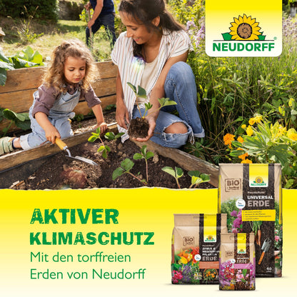 Een vrouw en een jong meisje planten zaailingen in een tuinbed met NeudoHum BlumenErde van de Neudorff Shop en bevorderen daarmee de actieve klimaatbescherming met deze turfvrije aarde.