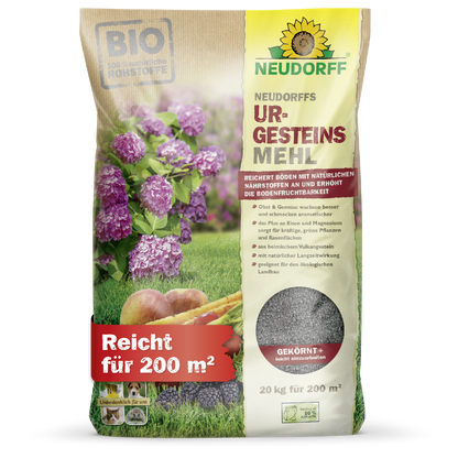 Ein 20-kg-Sack Neudorffs UrgesteinsMehl aus dem Neudorff Shop, abgebildet mit violetten Blumen, Möhren und Bodenbildern. Der Sack mit der deutschen Aufschrift deckt 200 m² ab und enthält Mineralpulver für die Verwendung im Boden.