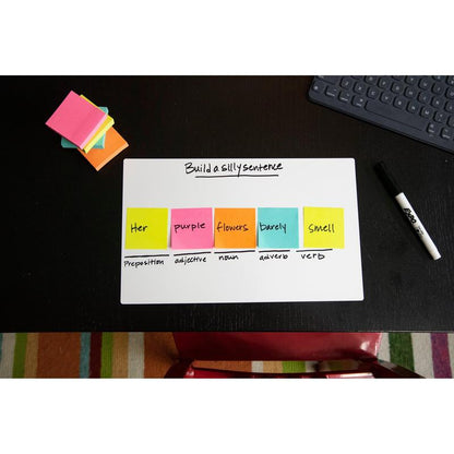 Op een zwart bureau staat een whiteboard met de tekst "Build a silly sentence". De Post-it® Notes kubus, Ultra-kleuren, 76x76 mm, van 3M Nederland B.V. tonen de woordsoorten. Verder op het bureau: een droog uitwisbare marker, een notitieblok en een toetsenbord.