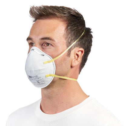Een man met kort bruin haar draagt een 3M™ deeltjesmasker 8710E FFP1 (van 3M Deutschland GmbH) met gele banden en zonder ventiel over neus en mond, gecombineerd met een eenvoudig wit overhemd tegen een witte achtergrond.