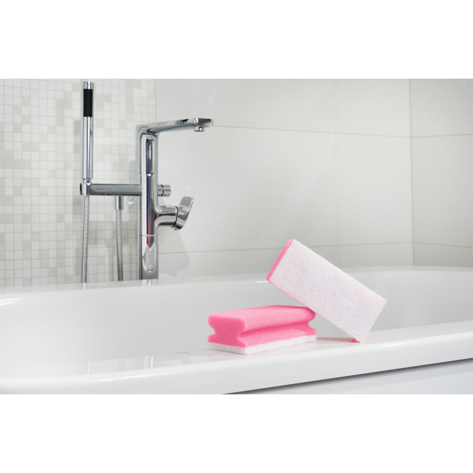 Ein Scotch-Brite® Bath Griffschwamm XXL von 3M Deutschland GmbH sitzt auf dem Rand einer weißen Badewanne mit einem verchromten Wasserhahn und einer gefliesten Wand im Hintergrund.