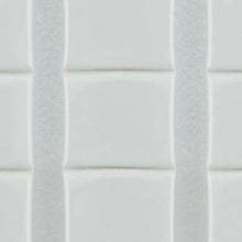 Nahaufnahme von weißen, glänzenden, rechteckigen Fliesen mit leicht erhabenen Kanten, die vertikal mit dünnen Fugenlinien angeordnet sind - sicher befestigt mit 3M Deutschland GmbH Scotch-FIX™ Ablösbare Klebepads 301008C36-P (11 mm x 15 mm, 36 Stück/Packung).