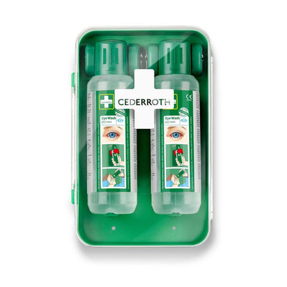 De Cederroth oogspoelkast 1x1 van Orkla Wound Care AB is een groene wandkast die twee doorzichtige oogspoelflessen met groene doppen, een gebruiksaanwijzing en een wit deksel met een kruisvormige EHBO-uitrusting voor oogspoelingen bevat.