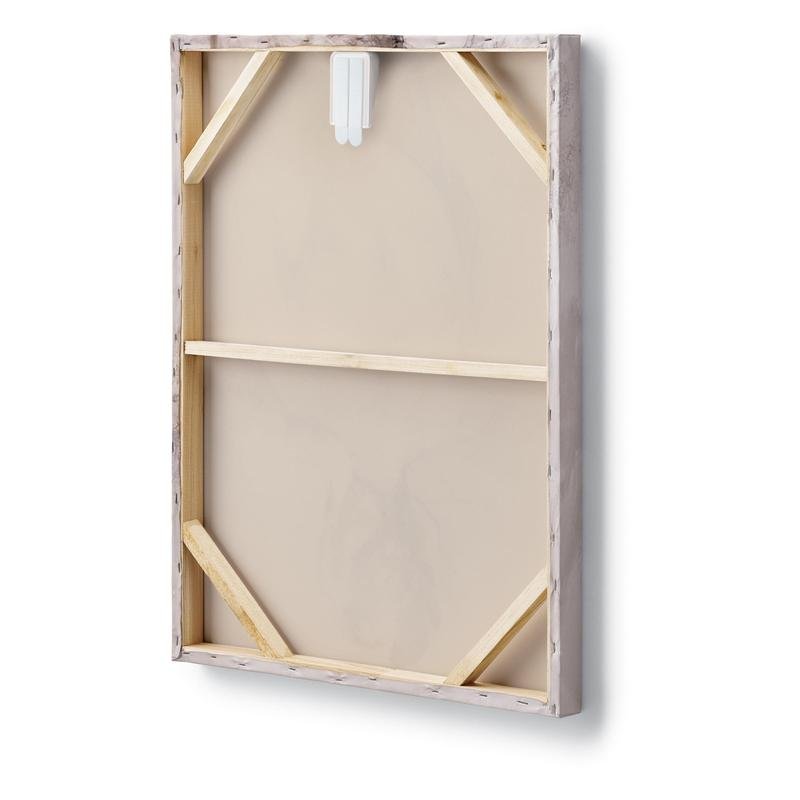 De afbeelding toont de achterkant van een rechthoekig opgespannen canvas met houten frame en versterkte hoeken, waarop bovenaan een witte Command™ canvasophanger van 3M Deutschland GmbH is aangebracht.