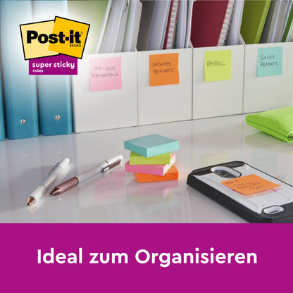 Ein Schreibtisch mit Ordnern, beschriftet mit Post-it® Super Sticky Notes, 76 mm x 76 mm, 45 Blatt/Block, von 3M Deutschland GmbH. Zu sehen sind gestapelte Notizen, Stifte, ein Telefon und Büromaterialien; Logo in der Ecke. Text: "Ideal zum Organisieren.