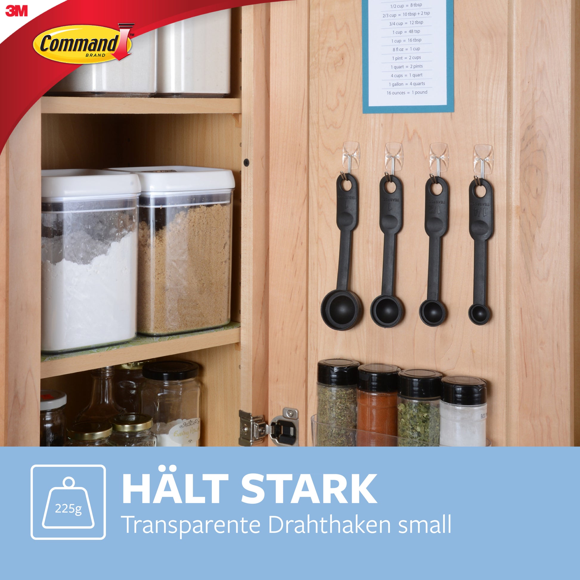 Ein hölzerner Küchenschrank zeigt die Command™ Drahthaken, klein, transparent, mit transparenten Strips der 3M Deutschland GmbH, die vier Messlöffel und Gewürzdosen halten; jeder Haken trägt bis zu 225 Gramm.