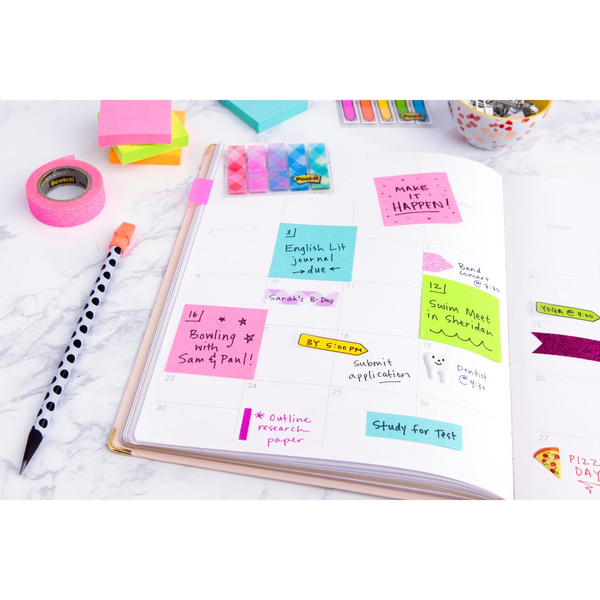 Auf einem weißen Schreibtisch liegen ein offener Planer mit handschriftlichen Notizen, ein gestreifter Stift, Büromaterial und bunte Post-it® Notes (76 mm x 127 mm, 100 Blatt/Block, 100% PEFC) der 3M Deutschland GmbH zum Markieren von Aufgaben und Terminen.