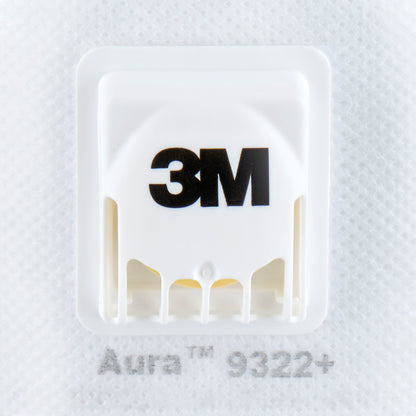 Close-up van een witte 3M™ Aura™ Comfort Cool Flow™ Particuliere Masker 9322+, FFP2, met ventiel van 3M Deutschland GmbH, die het merkventiel en de tekst "Aura 9322+" op de maskerstof toont.