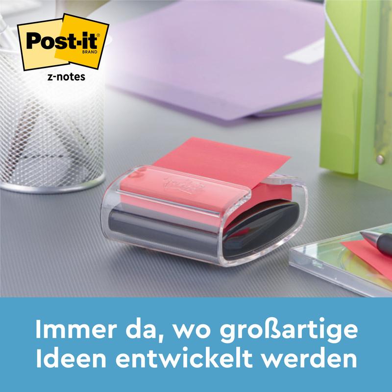 Een zwarte Post-it® Z-Notes Dispenser PRO met gele Super Sticky Z-Notes (76x76 mm, 90 vellen) van 3M Nederland B.V. staat op een bureau naast een pennenhouder, een groene map en een notitieboek. Tekst: "Altijd daar waar geweldige ideeën ontstaan."