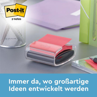 Een zwarte Post-it® Z-Notes Dispenser PRO met gele Super Sticky Z-Notes (76x76 mm, 90 vellen) van 3M Nederland B.V. staat op een bureau naast een pennenhouder, een groene map en een notitieboek. Tekst: "Altijd daar waar geweldige ideeën ontstaan."