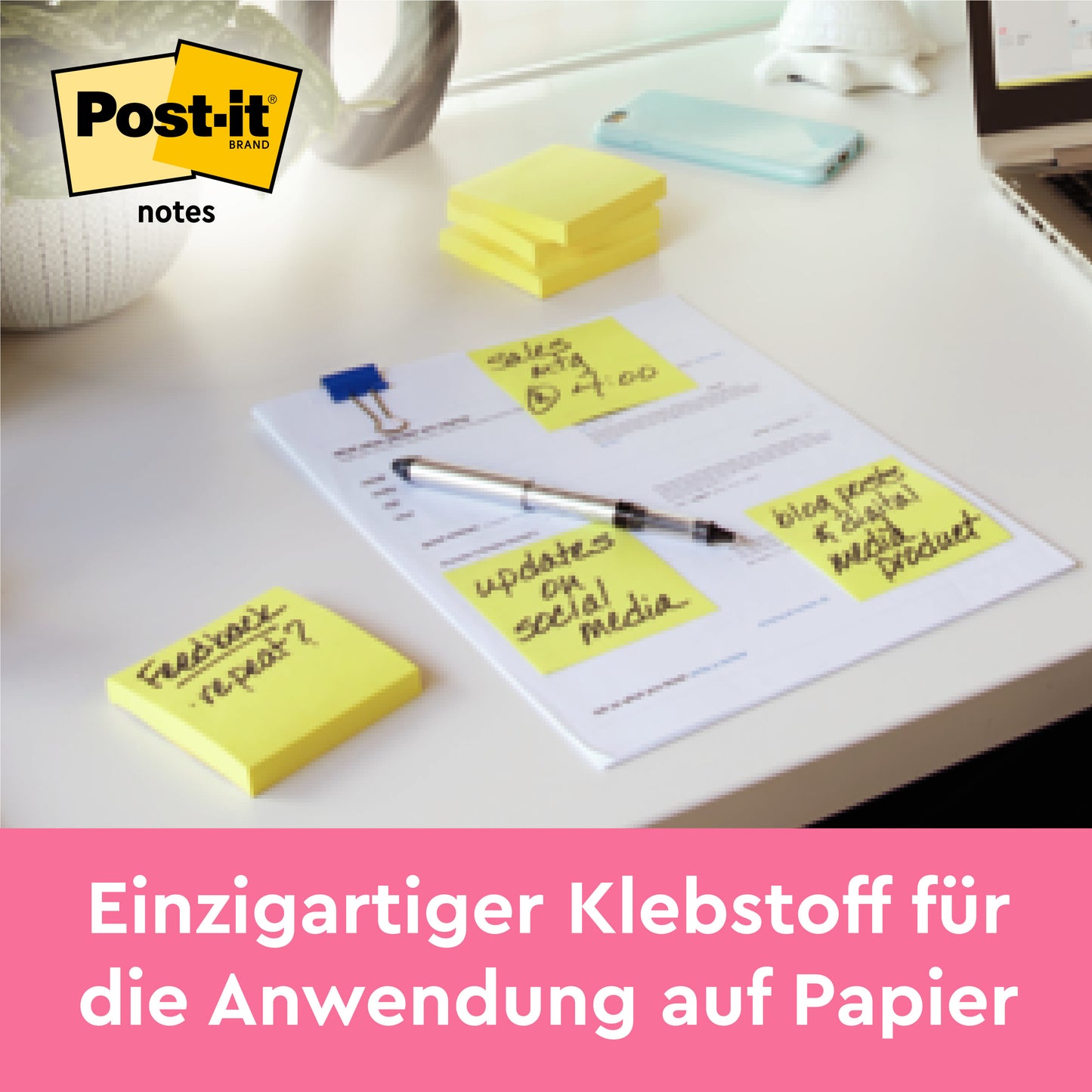 Auf einem Schreibtisch liegen Post-it® Notes und Super Sticky Notes von 3M Deutschland GmbH, beide in Gelb (76 x 76 mm); einige haften auf handbeschriebenen Dokumenten. Text: "Einzigartiger Klebstoff für Papieranwendung.