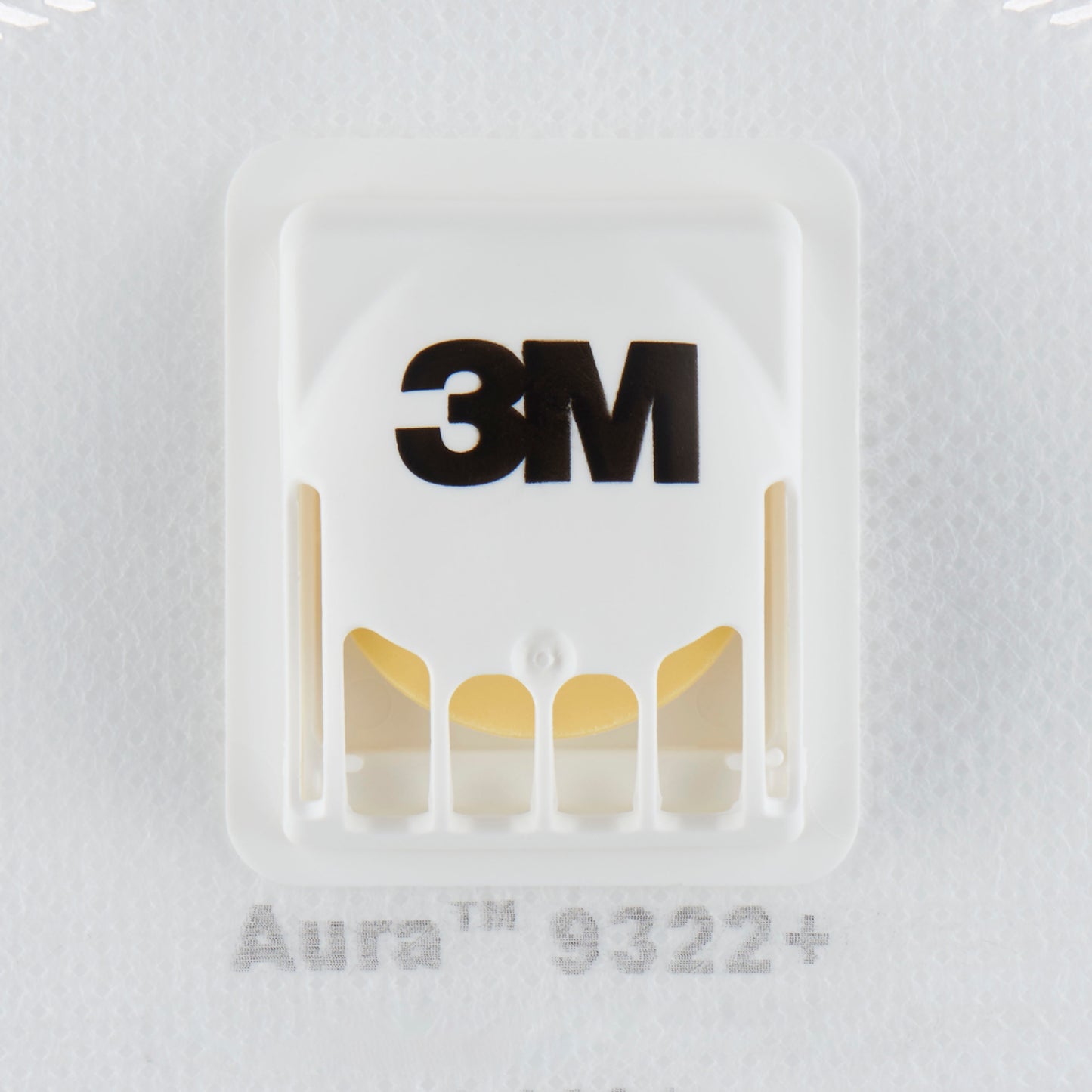 De close-up van een witte 3M™ Aura™ Comfort Cool Flow™ Particuliere Masker 9322+, FFP2, met ventiel van 3M Deutschland GmbH toont het zwarte 3M-logo, het geventileerde kunststofventiel en een deel van de modelaanduiding onder het ventiel.
