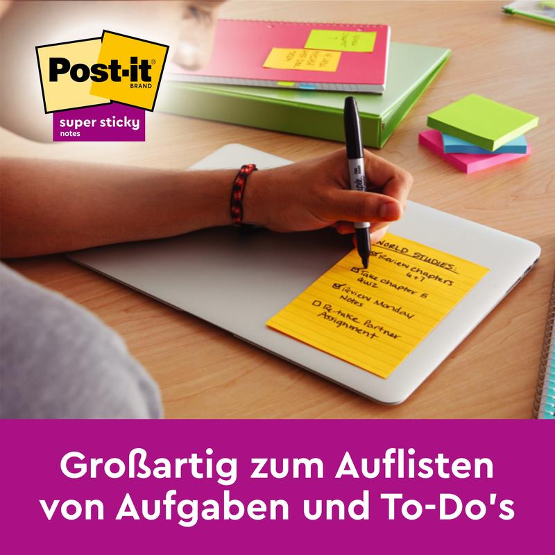 Een persoon schrijft op een gele Post-it® Super Sticky Note (101mm x 101mm, 90 vel, 100% PEFC) van 3M Deutschland GmbH op een gesloten laptop; andere kleurrijke kantoorartikelen zijn zichtbaar. De Duitse tekst luidt: "Geweldig voor het opsommen van taken en to-do's.