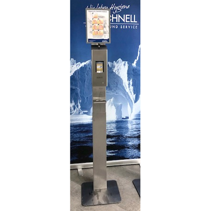 Ein Sanitizer-Spenderständer aus Edelstahl mit einer DR.SCHNELL GmbH & Co. KGaA Dr. Schnell Abtropfschale für Spender und einem digitalen Anleitungsbildschirm steht vor Eisbergen und Meer und schafft eine klare, moderne Atmosphäre.