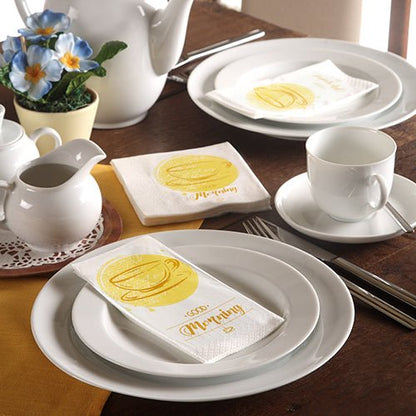 Een keurig gedekte tafel met wit servies, een theepot, blauwe bloemen en 3-laags PAPSTAR-servetten (33 x 33 cm) van de PAPSTAR GmbH met een gele koffiekop en het opschrift „Morning“.