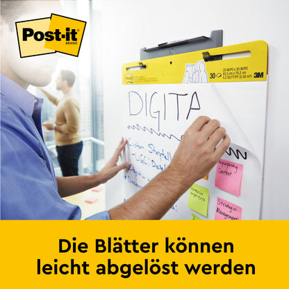 Eine Person schreibt auf einem 3M Deutschland GmbH Post-it® Super Sticky selbsthaftendes Mini Meeting Chart/Flipchart Mini 577SS, 38 x 45,7 cm, während bunte Haftnotizen den Block zieren. Am Boden steht: "Die Blätter können leicht abgelöst werden.