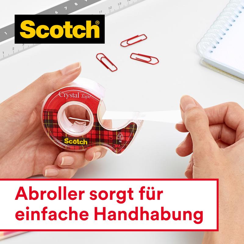 Een persoon trekt Scotch® Crystal plakband, transparant, voordeelverpakking (8 rollen, 19 mm x 33 m) van 3M Deutschland GmbH uit een rood geruite dispenser. Met paperclips, liniaal, notitieboek erbij. Duits: "Dispenser zorgt voor eenvoudige hantering.