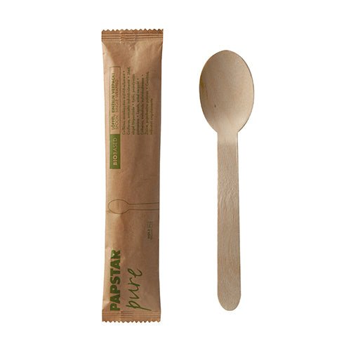 Een PAPSTAR houten lepel "pure" 16 cm, afzonderlijk verpakt in een papieren zakje, evenals de bruine verpakking met "PAPSTAR pure"-label zijn naast elkaar te zien tegen een witte achtergrond.