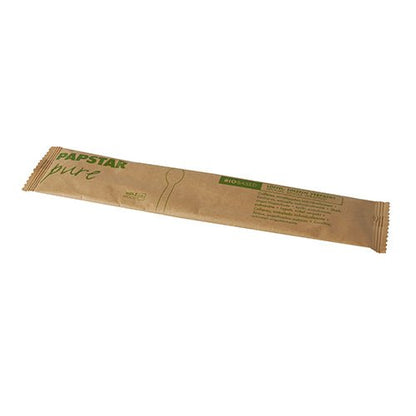 Een bruine papieren envelop met de opdruk "PAPSTAR pure" bevat een enkele 16 cm PAPSTAR houten lepel, afzonderlijk verpakt in papieren zakje/krimpfolie (50 stuks), met groene letters en een eenvoudige contour van gebruiksvoorwerpen van PAPSTAR GmbH.