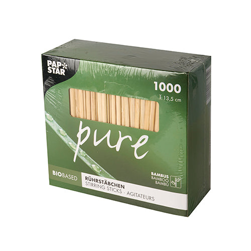 Een groene doos met het opschrift „pure“ bevat 1000 PAPSTAR bamboe roerstaafjes (13,5 cm, biologisch afbreekbaar). Linksboven bevindt zich het logo van de PAPSTAR GmbH; iconen wijzen op het milieuvriendelijke bamboemateriaal van de verpakking.