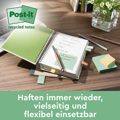 Een bureau met een open notitieboek waarin een groene Post-it® Super Sticky 100% Recycling Note (76x76 mm, 70 vel/Blok, 100% PEFC) van 3M Deutschland GmbH ligt, omgeven door plakbriefjes, pen, pennenhouder en glazen vaas. Tekst: "Hechten steeds weer."