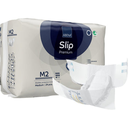 Achter een opengevouwen luier is een verpakking ABENA Slip Premium van Abena Re-Seller GmbH, maat M2, afgebeeld. Op de verpakking staat dat deze 24 middelgrote slips voor betrouwbare incontinentiezorg bevat.