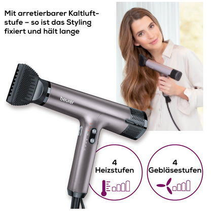 Een vrouw droogt haar lange, golvende haar met de zilveren Beurer HC 100 High Speed Haardroger Excellence van Beurer GmbH met ionenfunctie, 4 verwarmings-/luchtinstellingen en een vergrendelbare koude luchtfunctie in de Duitse taal.