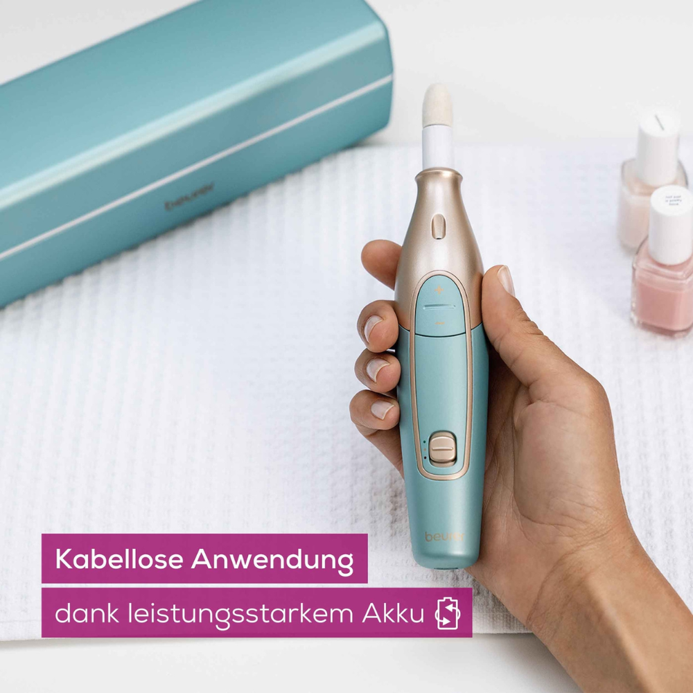 Een hand houdt de draagbare manicure- & pedicureset MP 84 van Beurer met blauwe behuizing, die op een gestructureerd wit oppervlak ligt. In de buurt staan nagellakflesjes en een opbergdoosje. In een tekstvak op de afbeelding staat 'Draadloos gebruik dankzij krachtige accu.'