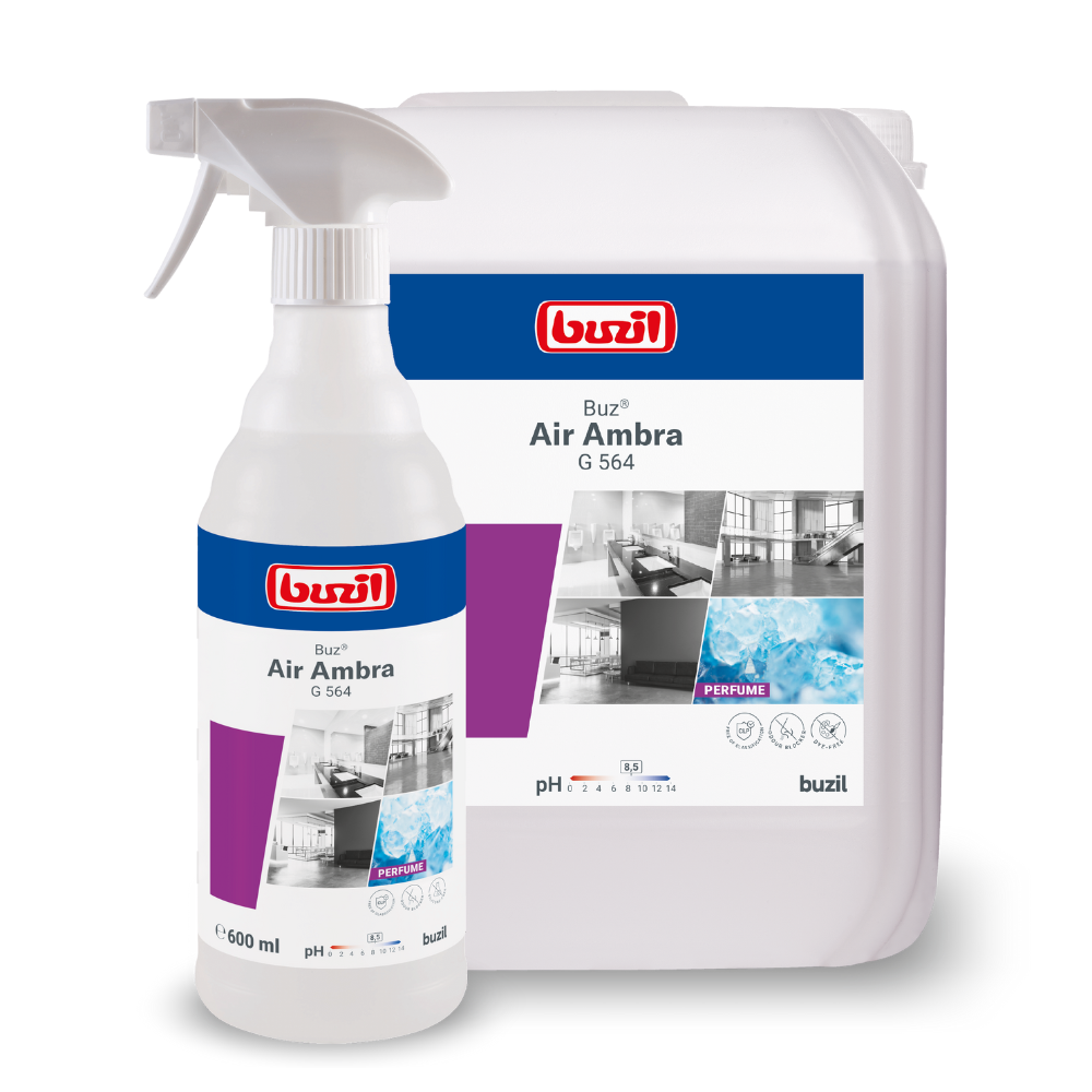 Getoond worden twee containers met reinigingsmiddelen: een spuitfles en een grote navulkan. Beide dragen het etiket "Buzil Buz® Air Ambra G 564 Gebruiksklare Ruimspray met Actieve Geurblokker" van BUZIL-WERK Wagner GmbH & Co. KG, waarop schone ruimtes en water zijn afgebeeld, evenals een actieve geurblokker voor langdurige frisheid.