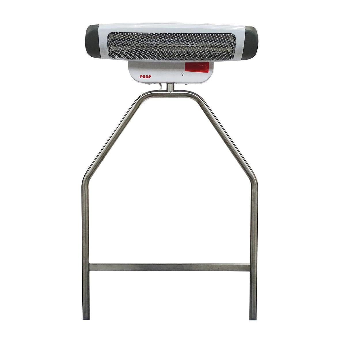 Op de Novocal roestvrijstalen houder voor verwarmers is een wit-grijze elektrische verwarming met metalen roosterafdekking en rood "reer"-logo gemonteerd, die als accessoire in het verschoningsgebied ideaal is voor veilige bevestiging aan een verschoningswagen.