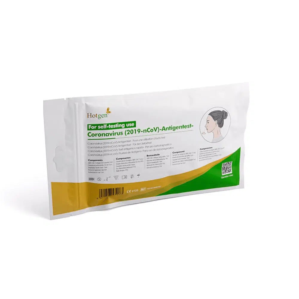 Een verpakking met de opdruk „Hotgen Sars-CoV-2 Antigen Laien Schnelltest CE0123 | Verpakking (1 test)“ voor zelftesten heeft groene en oranje accenten en toont een afbeelding van een persoon. De „Hotgen“-tekst is duidelijk zichtbaar in de linkerbovenhoek en markeert de test als een SARS-CoV-2-antigeentest.
